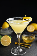 Delicious bee's knees cocktail and ingredients on black table