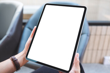 Mockup image of a woman holding digital tablet with blank white desktop screen in cafe