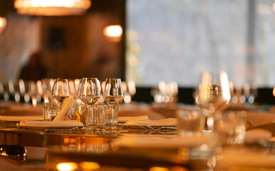 Luxury restaurant table decorations. Glasses and plates are set up on this beautiful table for serving the dinner during a beautiful sunset.