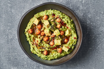 Vegan green avocado hummus with chia seeds and chickpeas.Green avocado vegan hummus garnished with smoked paprika olive oil and chia seeds. Vegan diet super food. 