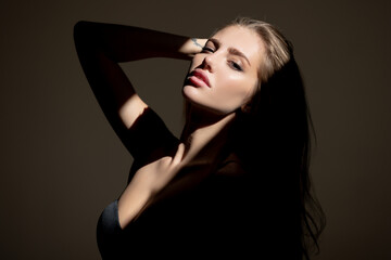 Fototapeta premium Beauty portrait of beautiful female model, fashion glamour portrait. Beauty female face. Sensual girl with art shadow light.