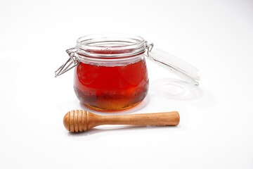 glass jar filled with honey on a white background