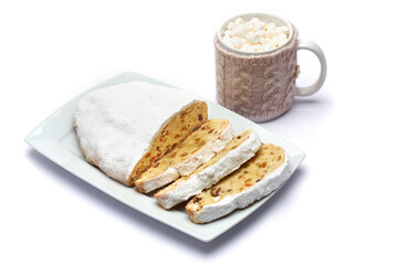 Sliced Traditional Christmas stollen cake with marzipan and dried fruit isolated on ceramic plate