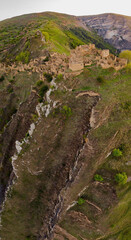 An ancient abandoned city is the village of Gamsutl on top of a mountain in Dagestan. A popular attraction. View from above from the drone. Vertical panorama. Tourist destination in Russia.