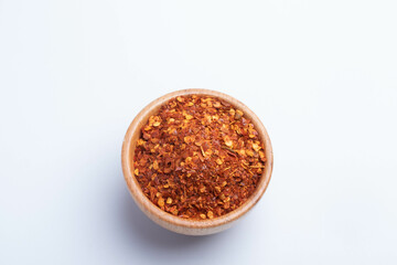 dried chili peppers in a wooden cup on a white background