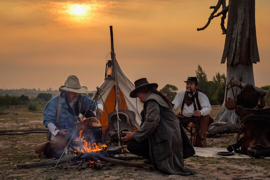Action image, vintage style of the cowboy group. Sit back and relax and have coffee in the morning camping in the golden light of the morning sun.