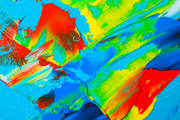 Closeup view of artist's palette with mixed bright paints as background