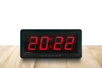 red led light illuminated numbers 2022 on digital electric alarm clock face on wooden table top...