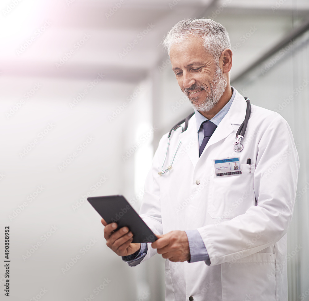 Aufkleber medical records at the touch of a button. shot of a mature doctor using a digital tablet in a hospit
