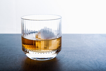 Sphere shaped ice cube and close up whiskey view from studio.