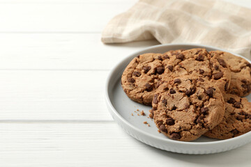 Delicious chocolate chip cookies on white wooden table. Space for text