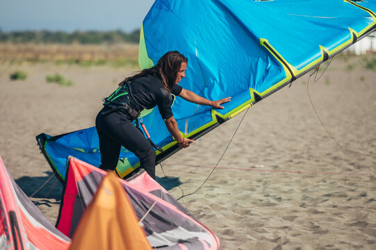 Young sporty woman preparing her kite for kitesurfing