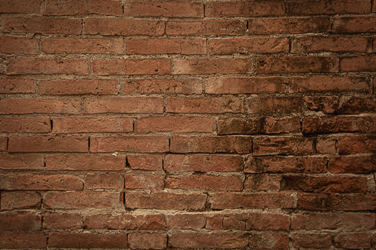 The old wall is made of red bricks.Texture of a wall made of antique bricks.Vintage red brick wall.