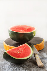 Watermelon cut into slices. Grey stone background. Autumn photos.