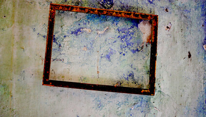empty abandoned picture frame still hanging on an old wall