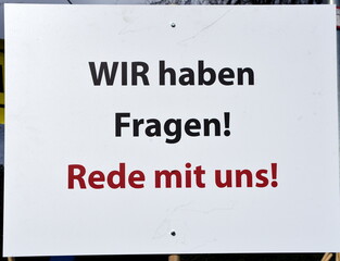 Schild auf einer Corona-Demo: "Wir haben Fragen! Rede mit uns!"