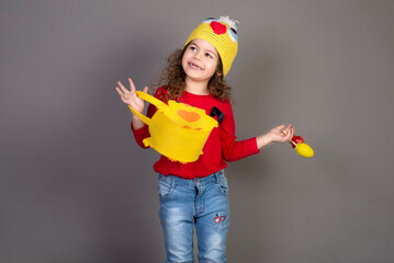 Little girl with a basket of eggs for the Easter holidays. Gray background for copying