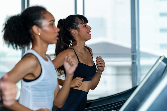 Healthy athletic woman in sportswear jogging workout exercise on treadmill at fitness gym. Wellness female do sport training cardio on running machine at sport club. Health care motivation concept