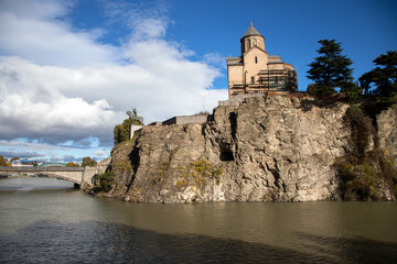 Fototapeta na wymiar Metekhi Church on the high cliff overlooking the Kura river