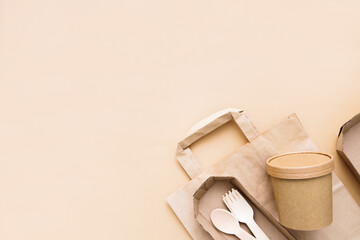 Environmentally friendly, disposable, cardboard, paper utensils  on a beige background. View from the top. Eco craft paper tableware. Production of disposable tableware.