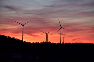 Windräder Windkraftanlagen mit Wolken und Abendrot bzw. Sonnenuntergang