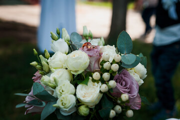 Beautiful bridal bouquet of flowers. Wedding rings on the bride's bouquet. Bridal bouquet close up
