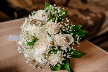 Beautiful bridal bouquet of flowers. Wedding rings on the bride's bouquet. Bridal bouquet close up