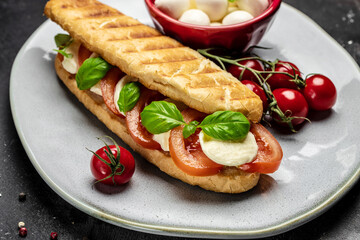 Delicious breakfast Caprese Panini Sandwich with tomato, mozzarella and basil, Clean eating, dieting, vegan food concept. top view