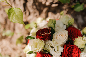 Beautiful bridal bouquet of flowers. Wedding rings on the bride's bouquet. Bridal bouquet close up