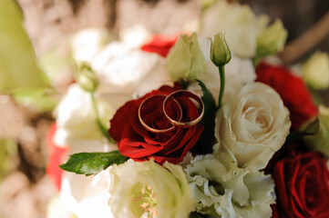 Beautiful bridal bouquet of flowers. Wedding rings on the bride's bouquet. Bridal bouquet close up