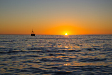 Boat trip towards sunset on Atlantic Ocean near Cape Town