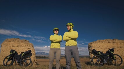 The man and woman travel on mixed terrain cycle bike touring with bikepacking. The two people...