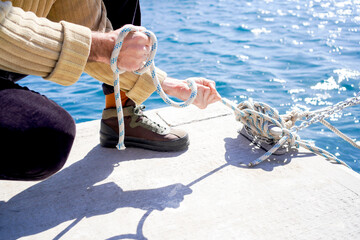 strong hands pulling hard on some ropes and moorings of a ship at the dock