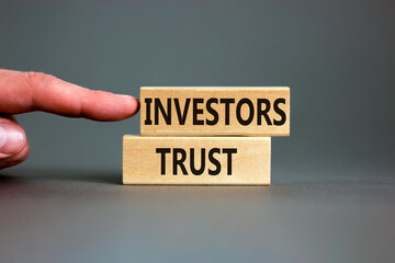 Investors trust symbol. Concept words Investors trust on wooden blocks on a beautiful grey table...