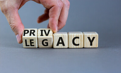 Privacy or legacy symbol. Businessman turns wooden cubes and changes the word Legacy to Privacy. Beautiful grey table grey background. Business privacy and legacy concept. Copy space.