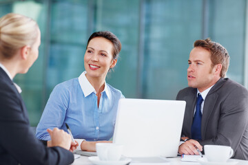 Sharing corporate suggestions with each other. Three business associates working together during a meeting.