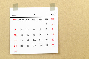 July 2022 calendar on brown background.