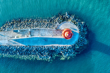Aerial view of Poolbeg Lighthouse the famous red landmark in Dublin Harbor Ireland seen by drone at...