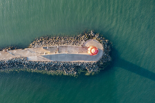 Aerial view of Poolbeg Lighthouse the famous red landmark in Dublin Harbor Ireland seen by drone at sunset