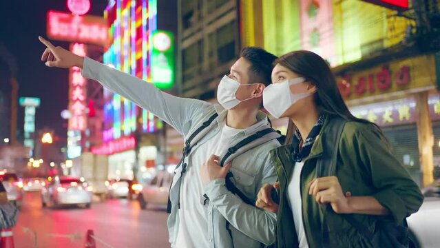 Asian attractive couple travel in the city for honeymoon trip at night