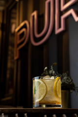 A glass of yellow ice lemonade in a dark bar, upwards photo