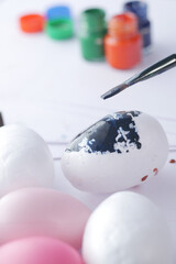 painting easter egg with a brush 