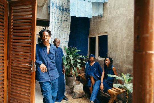 group portrait of african eco textile designers sitting outdoors, smiling