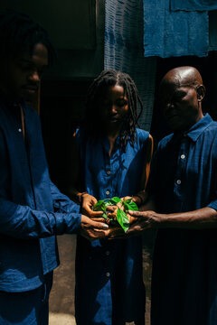 group portrait of eco fashion designers holding indigo plant 