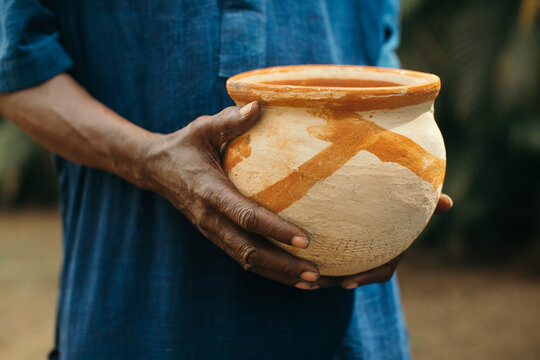 African older man holding pottery 