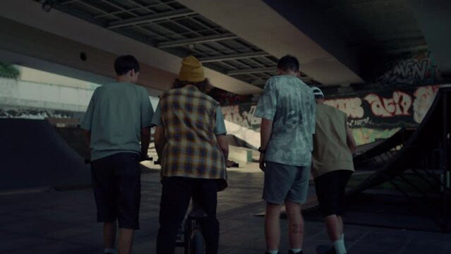 Teenage friends meeting together in urban skate park for leisure. Youth culture