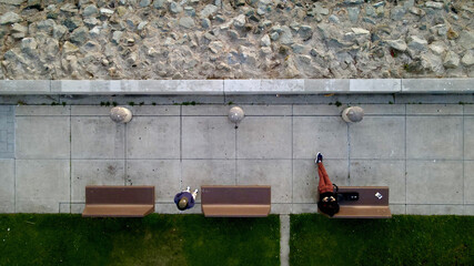 Top view of people on benches on a sidewalk