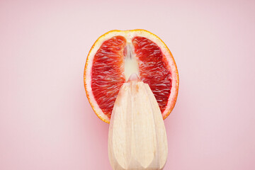 Juicy blood orange and condensed milk with a wooden juicer on a pink background. Top view. Sex...