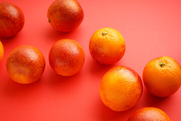 Ripe blood oranges on a red background, close-up.