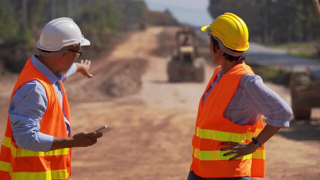 Surveyor builder Engineer road Male and female technician Business Team looking for blueprints in construction sites through blurry on road  construction site. Transport development concept.
